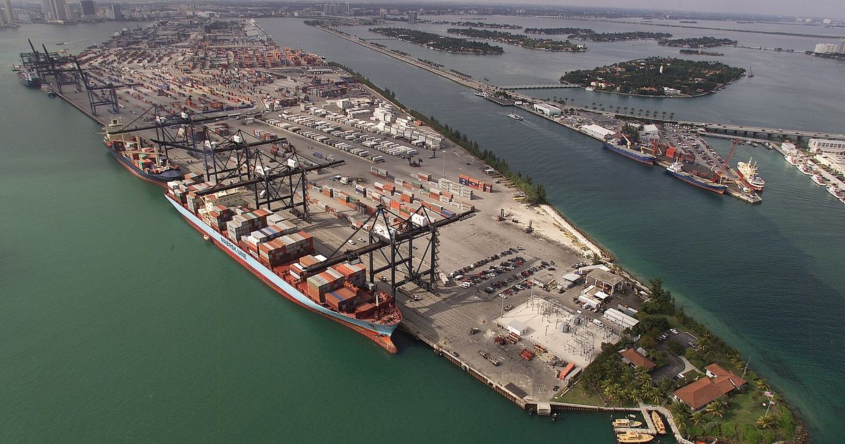 Aerial view of a container port with stacked shipping containers and cargo ships, representative of the sea-and-border trade loop behind Nepal's soybean oil re-exports
